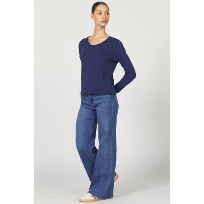 Woman wearing a blue sweater and jeans on a white background