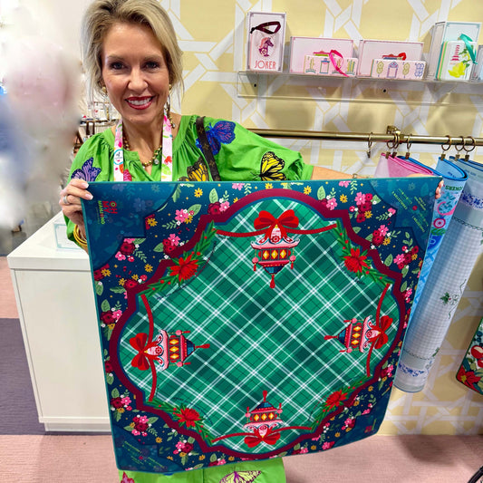 Woman holding a colorful fabric with floral and butterfly patterns in a store setting.