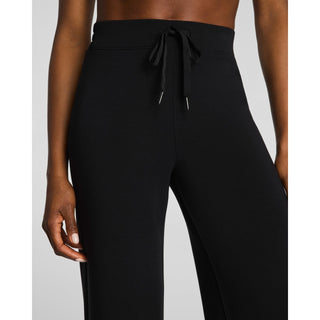 Black high-waisted wide-leg pants with a drawstring waist, shown on a model against a light gray background.