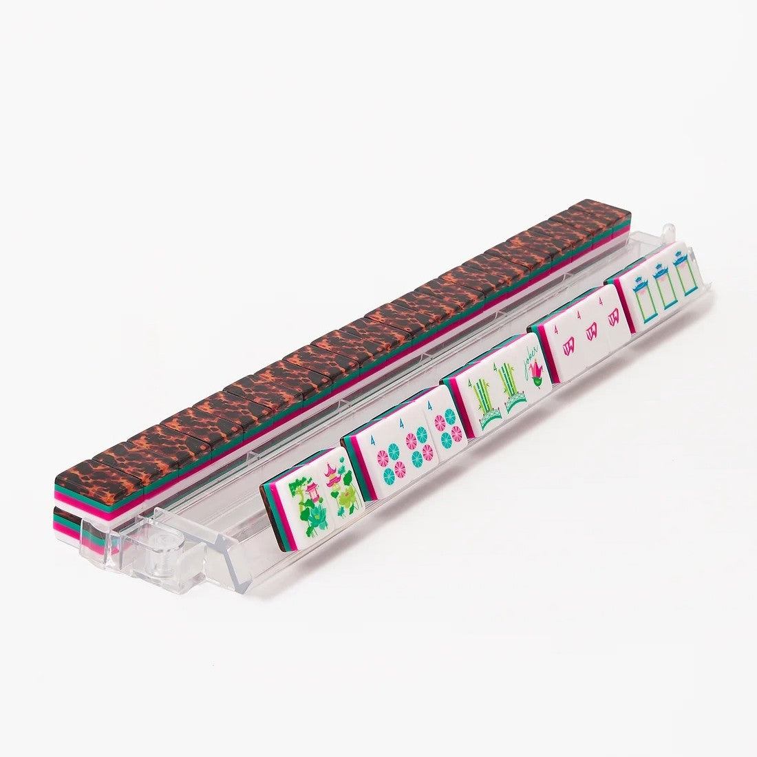 A clear acrylic mahjong rack holding multiple colorful mahjong tiles, with a textured dark brown and black patterned tile resting on top, photographed on a clean white background.