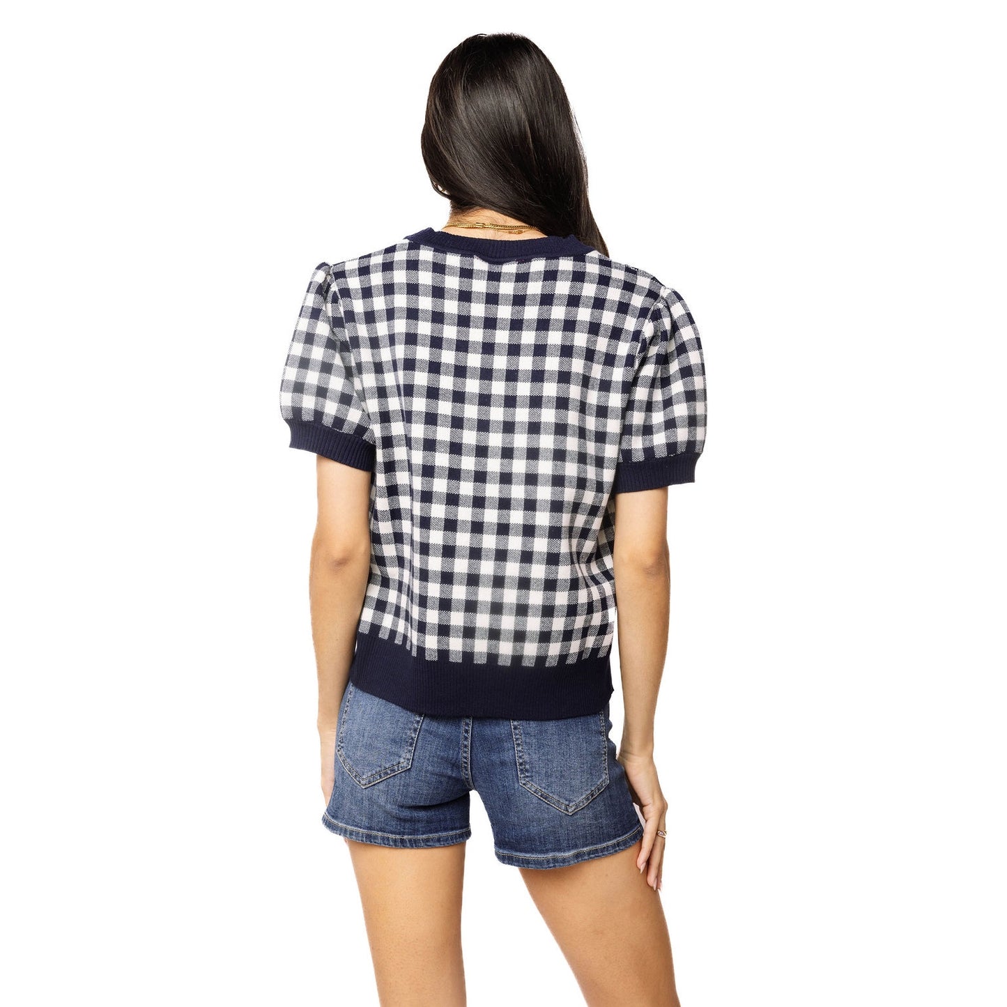 Person wearing a checkered shirt and denim shorts on a white background