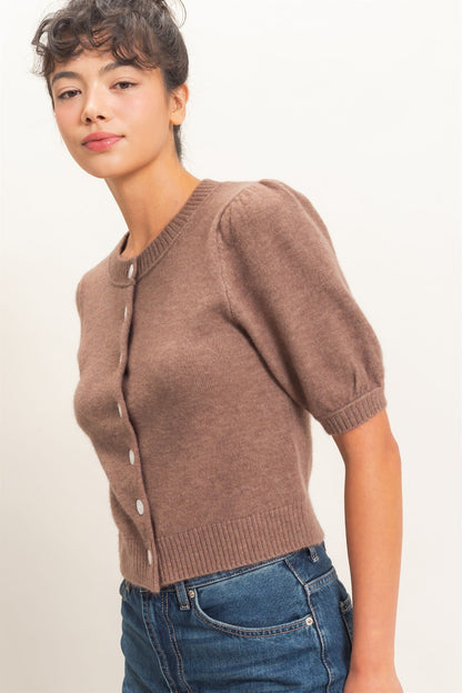 Woman wearing a brown cardigan over a white background